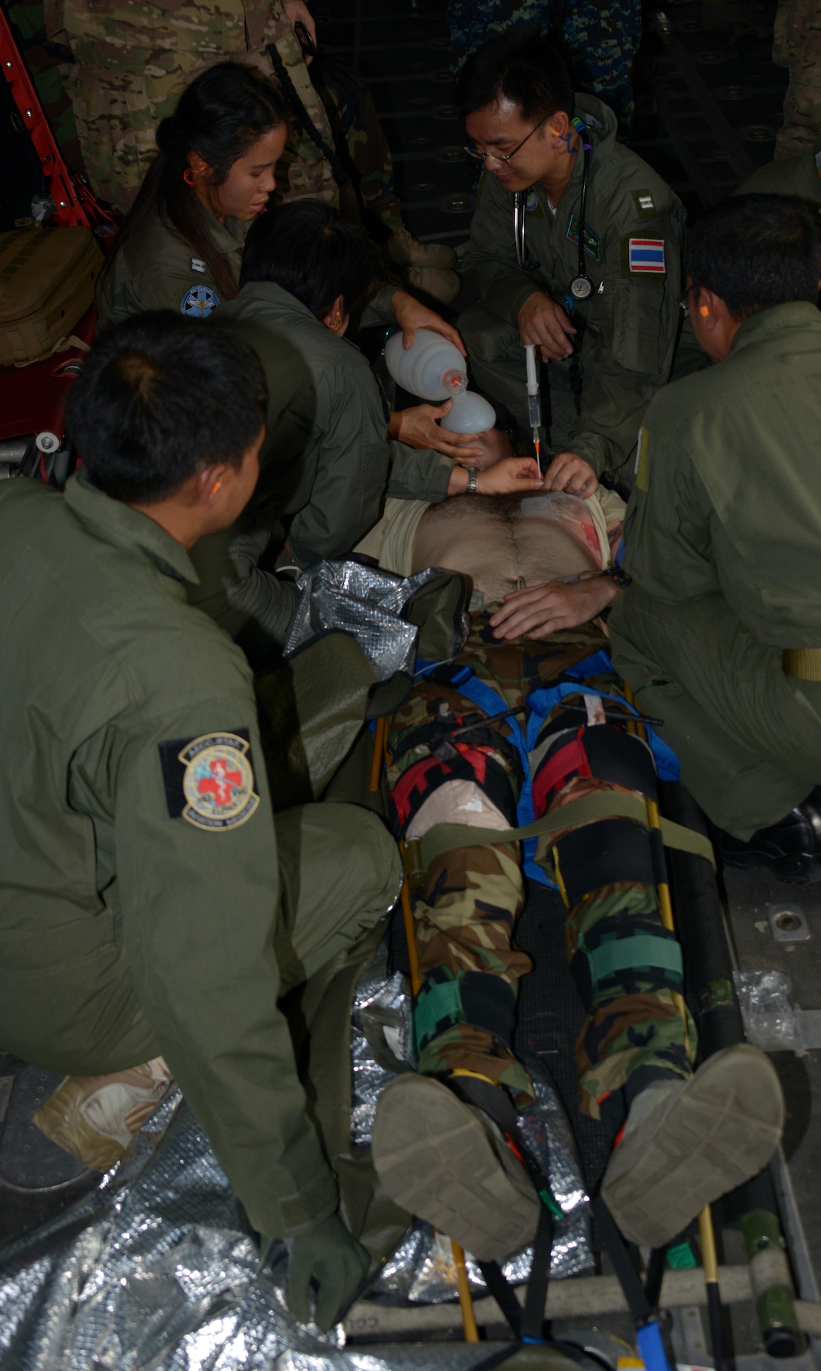Members from the Royal Thai Air Force work together to care for a patient on board an MC-130P Combat Shadow during a fly-away combat casualty evacuation exercise held during Teak Torch Feb. 6, 2014 in Udon Thani, Thailand.  Members of the Royal Thai Air Force and the 353rd Special Operations Support Squadron, Operations Support Medicine, came together during the training exchange to share techniques in combat casualty evacuations and tactical combat casualty care.  (U.S. Air Force photo by Tech. Sgt. Kristine Dreyer)