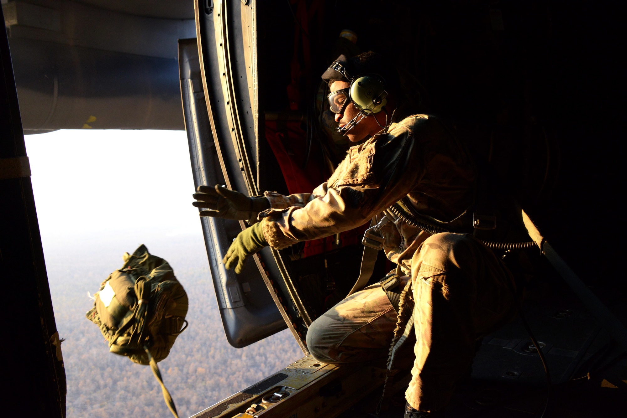 Tech. Sgt. David Wheeler, a loadmaster from the 17th Special Operations Squadron, drops a simulated airdrop training bundle from an MC-130P Combat Shadow over a drop zone near Udon Thani, Thailand. The MC-130P Combat Shadows from the 17th SOS are part of the 353rd Special Operations Group detachment from Kadena Air Base, Japan, in Thailand to participate in Exercise Teak Torch.  (U.S. Air Force photo by Tech. Sgt. Kristine Dreyer)
