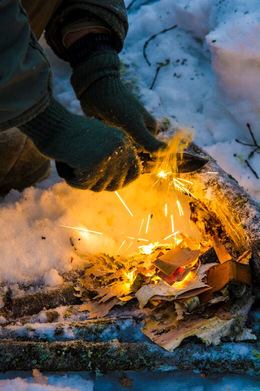 U.S. Air Force Tech. Sgt. Justin Carson, Detachment 1, 66th Training Squadron survival evasion resistance and escape specialist, prepares to start a fire during Artic Survival School training Feb. 6, 2014, Eielson Air Force Base, Alaska. Starting a fire was one of the many skills taught during the week-long “Cool School.” (U.S. Air Force photo by Senior Airman Joshua Turner/Released)