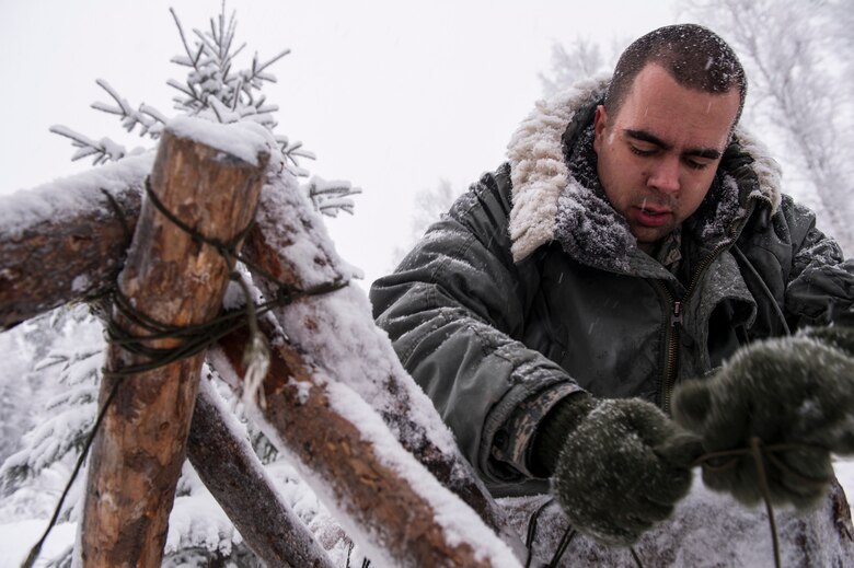 U.S. Air Force 2nd Lt. Elias Zani, 354th Fighter Wing Public Affairs deputy public affairs officer, prepares to build a thermalized A-frame shelter during Artic Survival School training Feb. 6, 2014, Eielson Air Force Base, Alaska. A portion of the training required Zani to construct a shelter to sleep in through the night. (U.S. Air Force photo by Senior Airman Joshua Turner/Released)