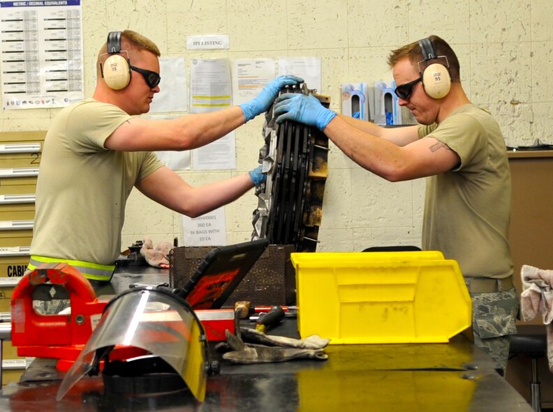 Senior Airman Jeremy Smith and Airman 1st Class Andrew Browning, 2nd Maintenance Squadron hydraulics systems journeymen, take apart a B-52H Stratofortress brake on Barksdale Air Force Base, La., Feb. 14, 2014. The brake parts were inspected for wear and corrosion, cleaned and then reassembled and tested before reattachment to the B-52. (U.S. Air Force Photo/Airman 1st Class Benjamin Raughton)