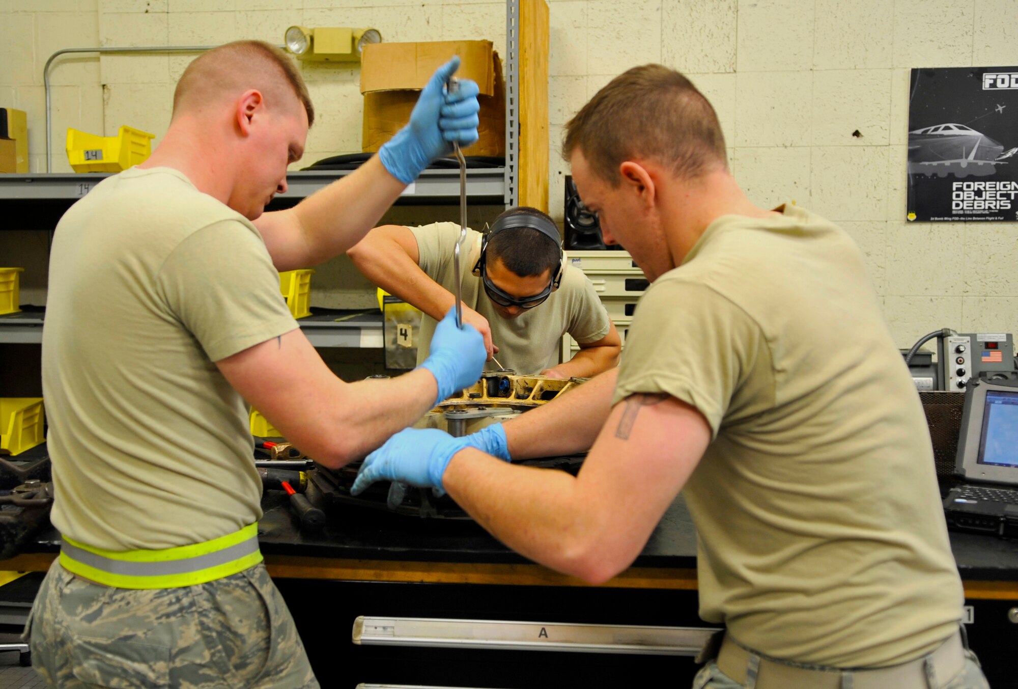 Airmen 1st Class Andrew Browning and Ronald Robert, and Senior Airman Jeremy Smith, all 2nd Maintenance Squadron hydraulics systems journeymen, disassemble a B-52H Stratofortress brake on Barksdale Air Force Base, La., Feb. 14, 2014. Hydraulics Airmen use a combination of conventional tools such as wrenches and pliers, as well as specialized tools such that remove grease from the parts. (U.S. Air Force Photo/Airman 1st Class Benjamin Raughton)