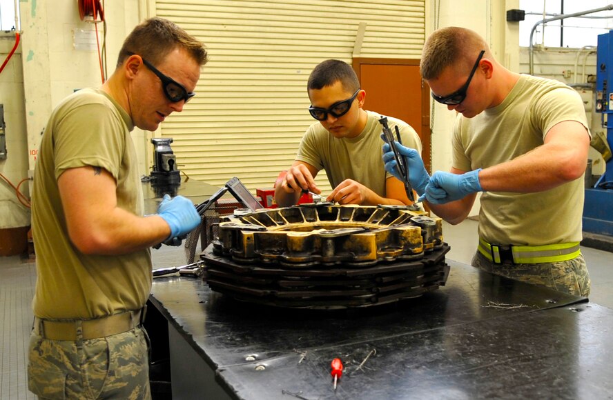 Airmen 1st Class Andrew Browning and Ronald Robert, and Senior Airman Jeremy Smith, all 2nd Maintenance Squadron hydraulics systems journeymen, disassemble a B-52H Stratofortress brake on Barksdale Air Force Base, La., Feb. 14, 2014. At times, parts cannot be taken apart and reassembled in a single shift; therefore later shifts will complete reassembly and testing. (U.S. Air Force Photo/Airman 1st Class Benjamin Raughton)