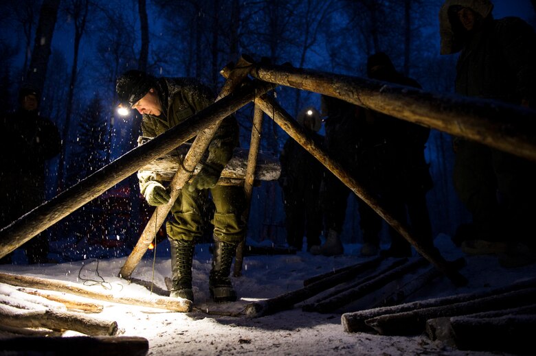 U.S. Air Force Staff. Sgt. Trent Carter, Detachment 1, 66th Training Squadron survival evasion resistance and escape specialist, demonstrates the construction of a thermalized A-frame shelter Feb. 6, 2014, Eielson Air Force Base, Alaska. The A-frame was built with pre-cut logs and a tarp was used as a cover. The shelter was also covered with eight inches of snow for insulation. (U.S. Air Force photo by Senior Airman Joshua Turner/Released)