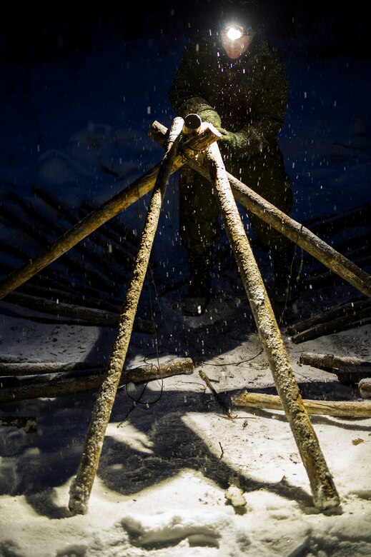 U.S. Air Force Staff. Sgt. Trent Carter, Detachment 1, 66th Training Squadron survival evasion resistance and escape specialist, demonstrates the construction of a thermalized A-frame shelter Feb. 6, 2014, Eielson Air Force Base, Alaska. Carter helps provide arctic survival training to U.S. military and allies. (U.S. Air Force photo by Senior Airman Joshua Turner/Released)