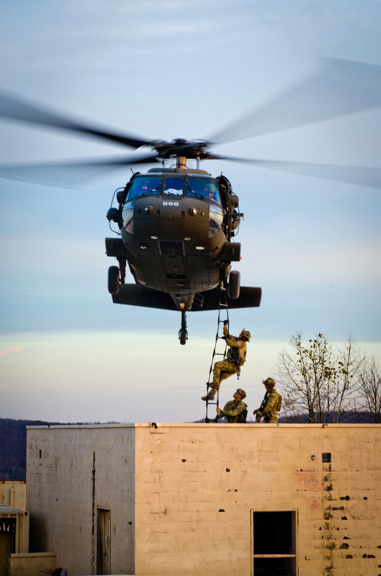 Members of the Kentucky Air National Guard’s 123rd Special Tactics Squadron climb a rope ladder onto a Kentucky Army National Guard UH-60 Blackhawk during training at Zussman Range at Fort Knox, Ky., on Nov. 21, 2013. The Airmen were practicing insertions, extractions and close-quarters combat in a simulated Afghan village. (U.S. Air National Guard photo by Master Sgt. Phil Speck)
