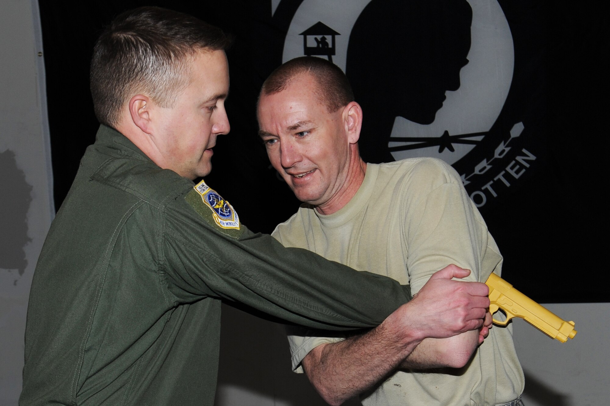 Master Sgt. Jamie Smith is restrained by another student while practicing disarming a weapon at Scott Air Force Base, Ill. Feb. 12, 2014. This was part of a Survival, Evasion, Resistance and Escape (SERE) training course which had students learning and demonstrating how to disarm a weapon from the front and back. Smith is with Air Mobility Command headquarters (U.S. Air Force photo/Airman 1st Class Megan Friedl)