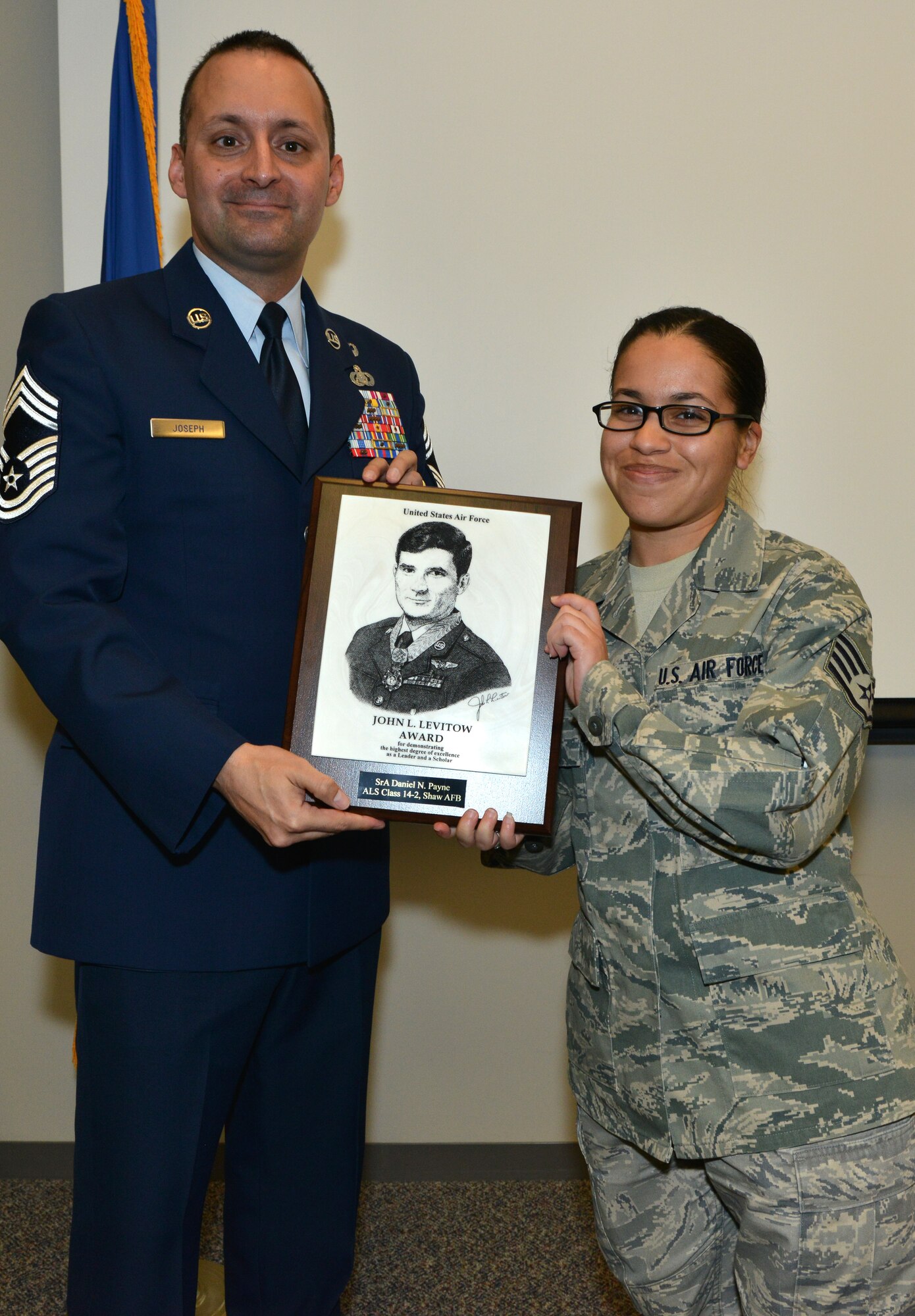 Staff Sergeant Danielle Payne, 31st Intelligence Squadron, is presented the John L. Levitow Award by Chief Master Sergeant Michael Joseph, 20th Force Support Squadron superintendent, Feb. 18, 2014 at Shaw Air Force Base, S.C. The John L. Levitow Award is presented to the student who demonstrated the highest degree of excellence as a leader and a scholar. (U.S. Air Force photo by Airman 1st Class Jensen L. Stidham/released)