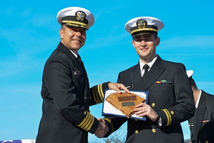 Capt. Jon Fahs, Naval Nuclear Power Training Command commanding officer, presents Ens. Zach Bunting with a command plaque and award certificate Feb. 14, 2014, after graduating with the highest officer class grade point average at a graduation ceremony for Nuclear Power School Class 1306 at Joint Base Charleston – Weapons Station, S.C. (US Navy Photo/ Petty Officer 3rd Class Jason Pastrick)