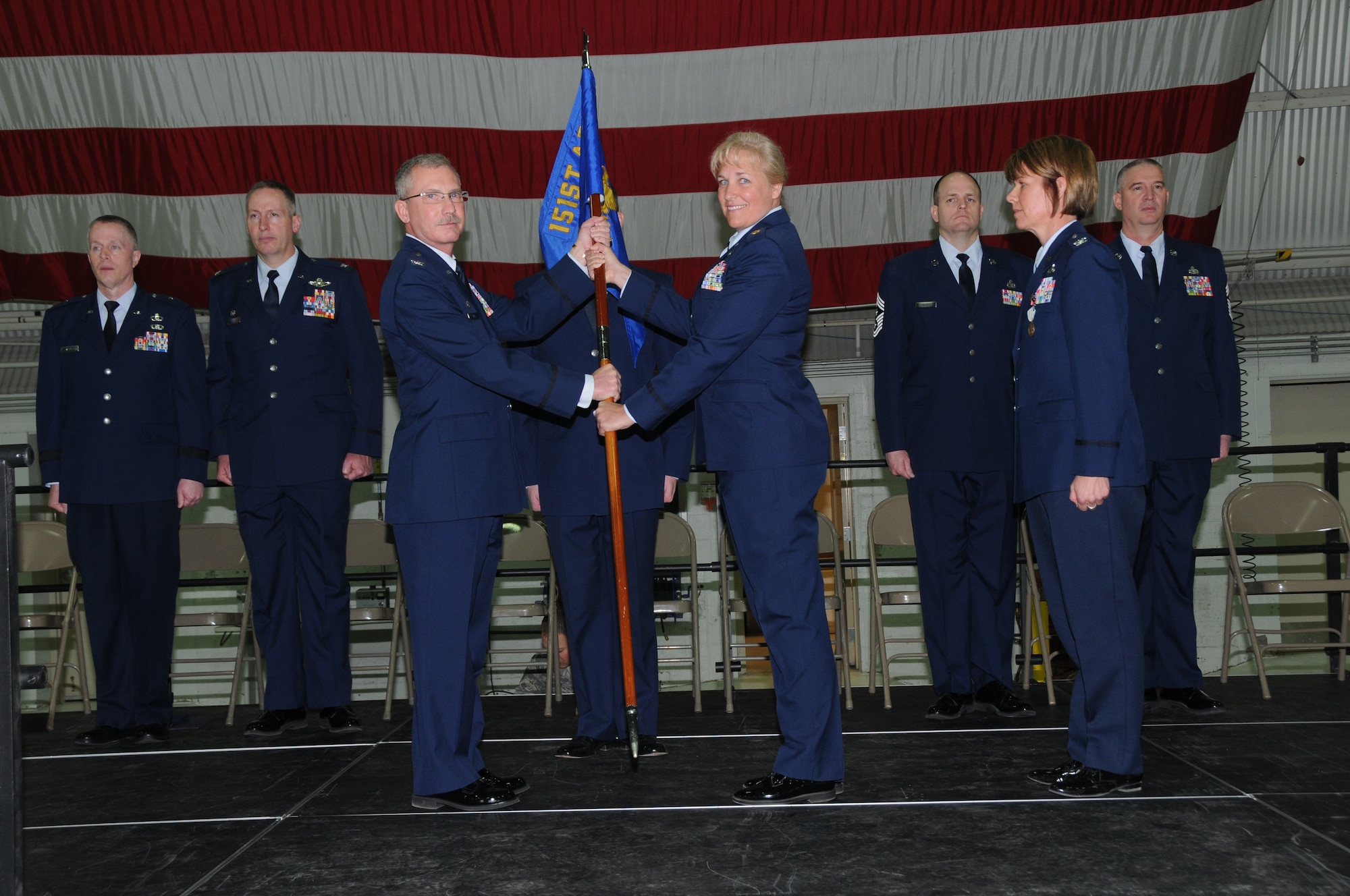 Col. Jack Wall hands the unit flag to Maj. Christina Lock, the incoming 151 LRS Commander as Col. Susan Melton looks on after relinquishing her command during a change of command ceremony held at the Utah National Guard Air Base in Salt Lake City, Utah, February 9, 2014. (Utah Air National Guard photo by TSgt Amber Monio) (Released)