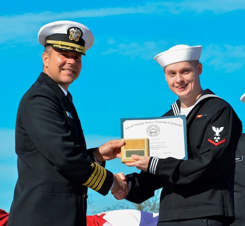 Capt. Jon Fahs, Naval Nuclear Power Training Command commanding officer, presents Petty Officer 3rd Class Scott Sam, a machinist’s mate, with a command plaque and award certificate Feb.14, 2014, for graduating with the highest grade point average in his class at a ceremony for Nuclear Power School Class 1306 at Joint Base Charleston – Weapons Station, S.C. (US Navy Photo/ Petty Officer 3rd Class Jason Pastrick)