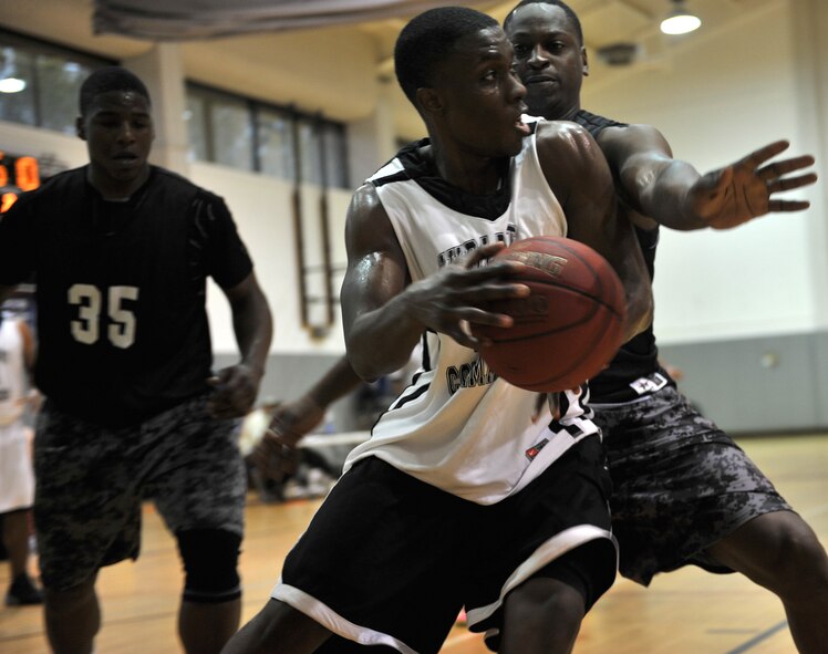 Jacob Sullivan, Hurlburt Commandos forward, maneuvers for an opening against Alfonzo Magsby, Gordon Eagles center, at the Aderholt Fitness Center on Hurlburt Field, Fla., Feb. 17, 2014. “One of the biggest challenges our team faced during the tournament was trusting each other and making the extra passes to the open players,” said Dexter Mitchell, Hurlburt Commandos coach. (U.S. Air Force photo/Senior Airman Kentavist P. Brackin) 