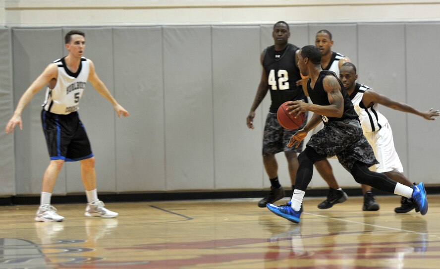 Shedric McElderry, Gordon Eagles shooting guard, attempts to dribble past Hurlburt Commandos defenders during the final game of the Southeast Military Athletic Conference Basketball Tournament at the Aderholt Fitness Center on Hurlburt Field, Fla., Feb. 17, 2014. The Eagles were the No. 1 seeded team during the regular season, with a record of 10-2.