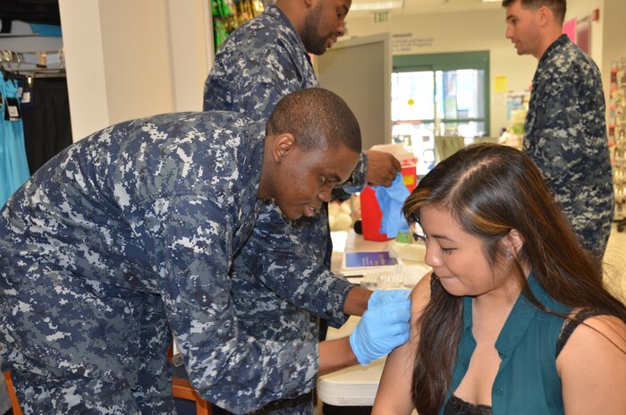 Petty Officer 2nd Class David Oba, Naval Health Clinic Charleston preventative medicine technician, administers a flu vaccination to a patient during a flu vaccination clinic Feb. 6, 2014, at the Navy Exchange on Joint Base Charleston - Weapons Station. (U.S. Navy photo/Eric Sesit)