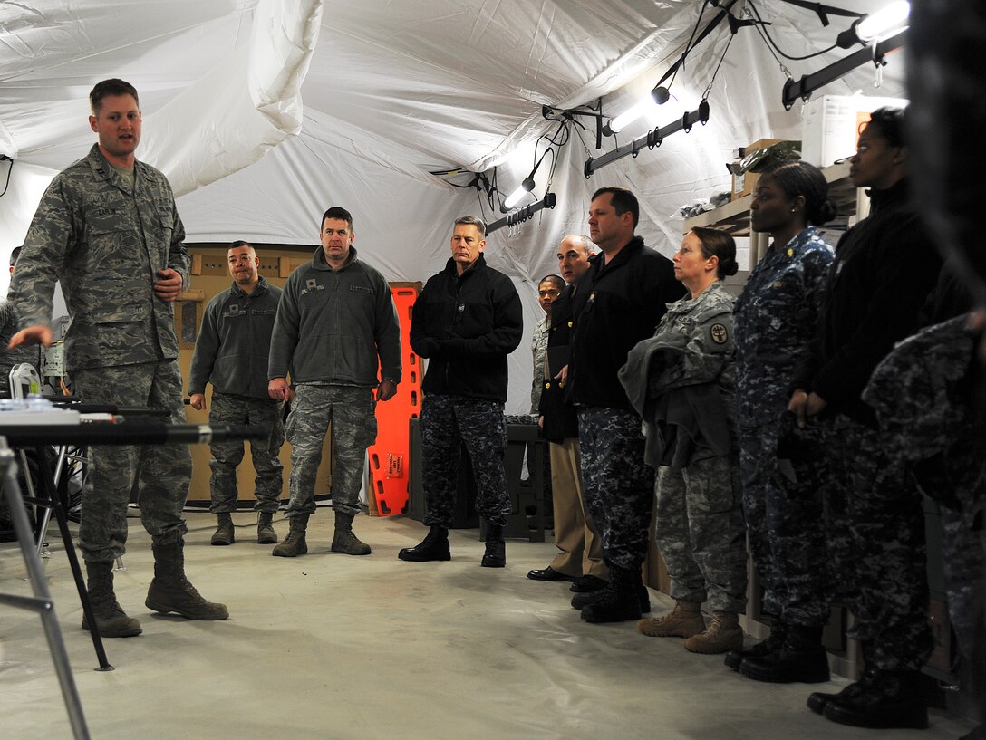 Capt. Benjamin Barlow gives a presentation to Joint Service members and partners from Ft. Eustis and the Naval Medical Center Portsmouth, Va.. The joint-service visited the Expeditionary Medical Support System exercise location 17 February, 2014. The visit was to see if they can incorporate the modernization of the new tent systems and equipment into their expeditionary operations. (U.S. Air Force photo by Staff Sgt. Steve Stanley/Released)