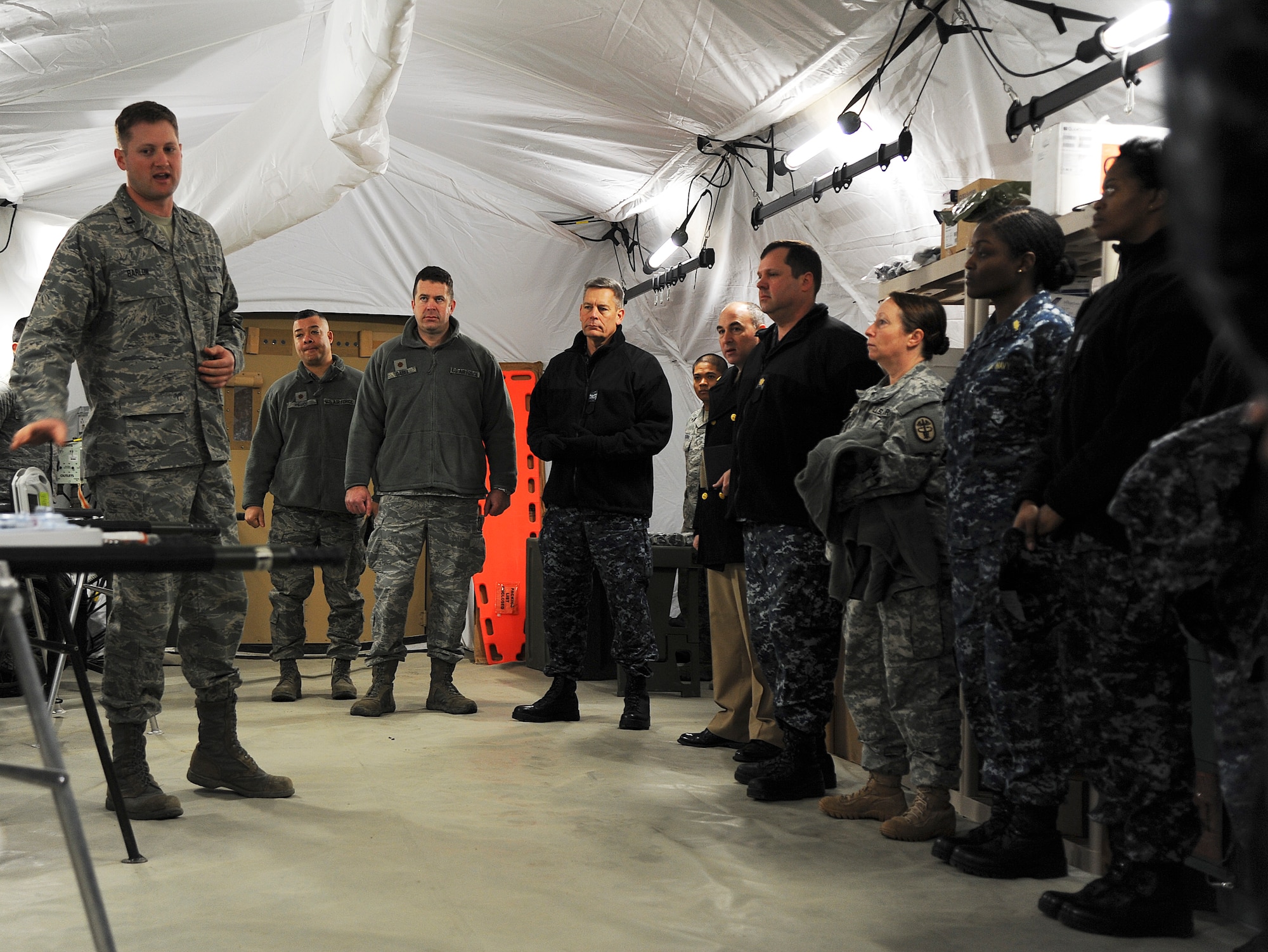 Capt. Benjamin Barlow gives a presentation to Joint Service members and partners from Ft. Eustis and the Naval Medical Center Portsmouth, Va.. The joint-service visited the Expeditionary Medical Support System exercise location 17 February, 2014. The visit was to see if they can incorporate the modernization of the new tent systems and equipment into their expeditionary operations. (U.S. Air Force photo by Staff Sgt. Steve Stanley/Released)