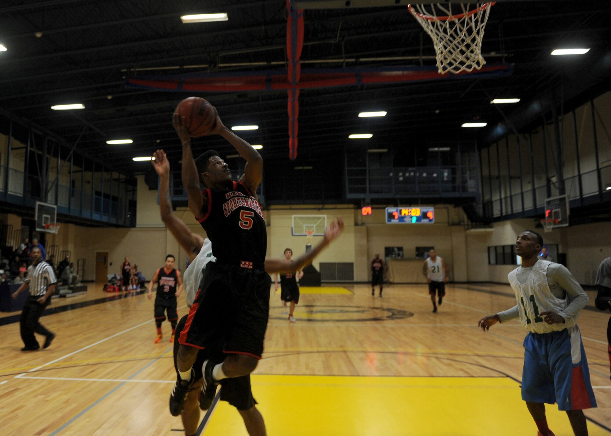 A member from the Little Rock Air Force Base intramural basketball team jumps to shoot a basket Feb. 14, 2014, at Little Rock Air Force Base, Ark. The Airmen were playing in the intramural championship against a group of Army National Guardsmen from Camp Robinson. (U.S. Air Force photo by Airman 1st Class Scott Poe)
