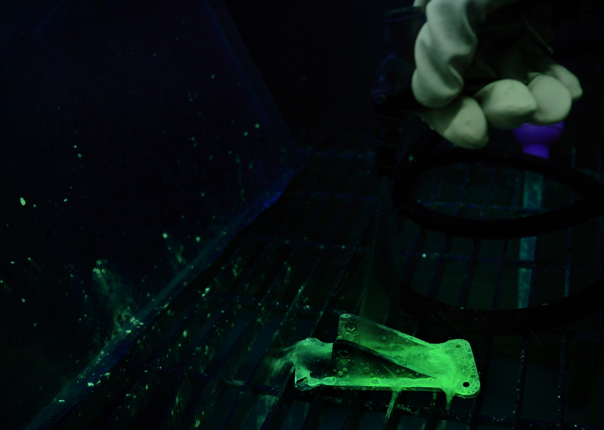 U.S. Air Force Senior Airman Bradley Johnson, 100th Maintenance Squadron non-destructive inspection journeyman from Bakersfield, Calif., sprays the excess penetrant off a KC-135 Stratotanker horizontal hinge bracket Feb. 11, 2014, on RAF Mildenhall, England. After rinsing off the penetrant, only areas of the part affected by cracks will have penetrant left on them, thus allowing an inspector to see the defects. Once the penetrant has set into a crack, it is safe to rinse the rest of the part before inspection. (U.S. Air Force photo by Airman 1st Class Dillon Johnston/Released)
