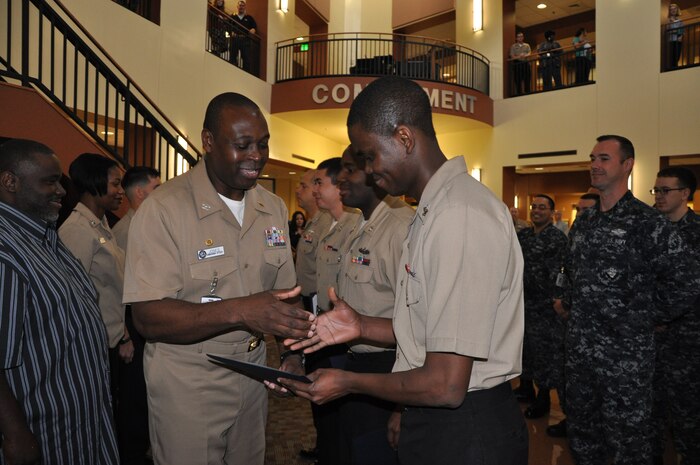 Navy Capt. Marvin Jones, Naval Health Clinic Charleston commanding officer, congratulates Petty Officer 2nd Class David Oba, NHCC preventive medicine technician during a frocking ceremony Dec. 10, 2014, at NHCC on Joint Base Charelston - Weapons Station. 