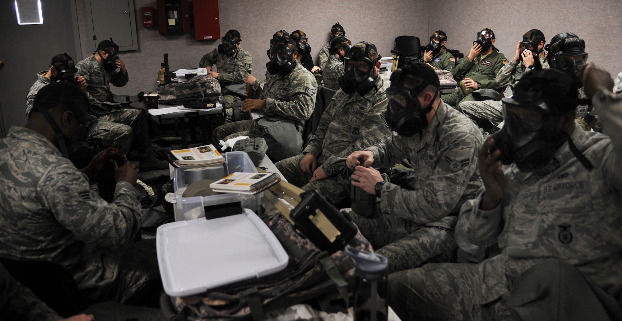 A group of Airmen try on the M50 gas mask as part of a chemical, biological, radiological and nuclear defense class Feb. 12, 2014, at Little Rock Air Force Base, Ark. The gas mask is an essential piece of the mission oriented protective posture gear, which is a vital part of CBRN defense. (U.S. Air Force photo by Airman 1st Class Harry Brexel)