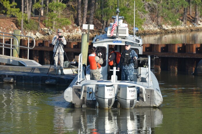Airman 1st Class Sydney Manning (center) videotapes an interview with Petty Officer 2nd Class Jeremiah Parker (right) while Staff Sergeant Aaron Thomasson documents the interview Feb. 19, 2014, at Joint Base Charleston – Weapons Station, S.C. Parker is a Navy master-at-arms assigned to the 628th Security Forces Harbor Patrol Unit. Thomasson and Manning are Air Force broadcasters and were capturing video for a documentary on the 628th SFS Harbor Patrol Boat operations. (U.S. Navy photo/Eric Sesit)