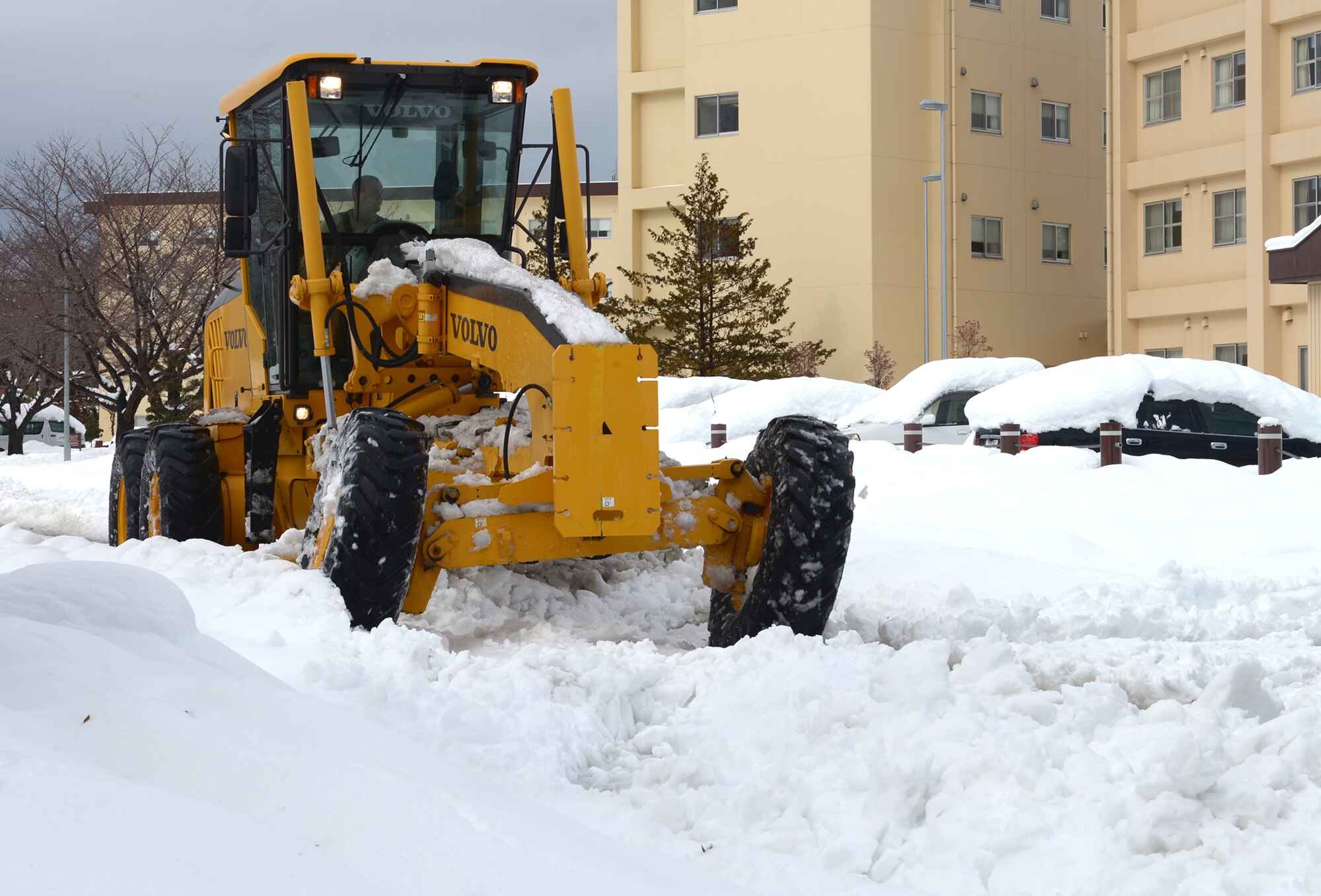 An Airman with the 374th Civil Engineer Squadron Horizontal “Dirt Boyz” shop plows streets in a 120-M Grader at Yokota Air Base, Japan, Feb. 15, 2014. Yokota accumulated 21 inches of snow over the course of 24 hours, causing the “Dirt Boyz” to use all available vehicles during base recovery. (U.S. Air Force photo by Airman 1st Class David Danford/Released) 