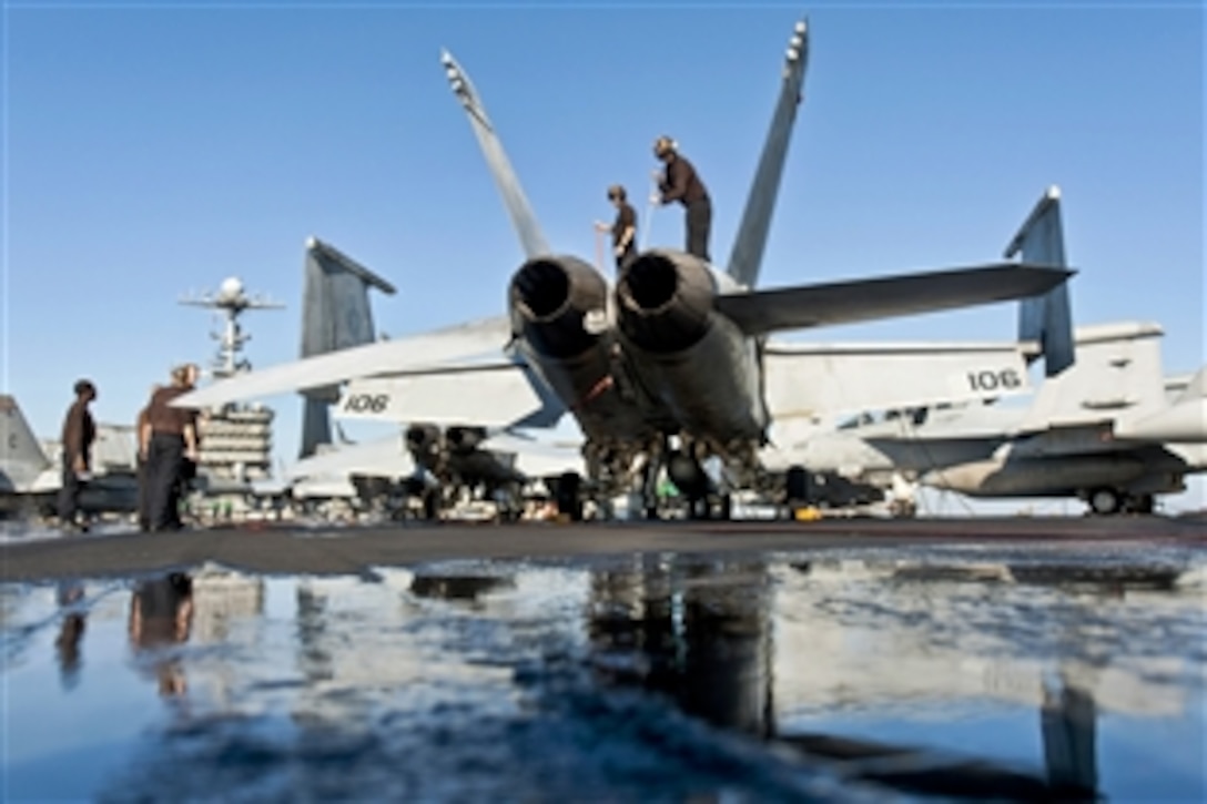 U.S. sailors wash an F/A-18F Super Hornet aircraft on the flight deck of the aircraft carrier USS Harry S. Truman in the Gulf of Oman, Feb. 16, 2014. The Harry S. Truman Carrier Strike Group deployed to the U.S. 5th Fleet area of responsibility to conduct maritime security operations, support theater cooperation efforts and support Operation Enduring Freedom. The sailors are assigned to Strike Fighter Squadron 32.