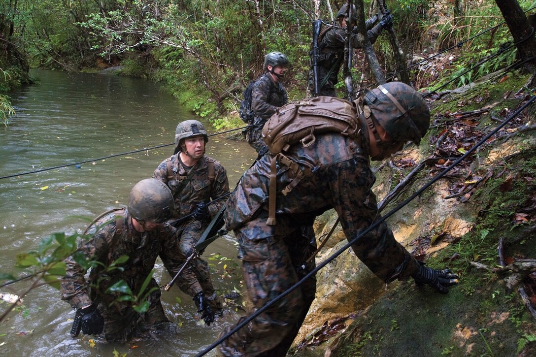 Marines climb ashore Feb. 12 at the Jungle Warfare Training Center after passing through one of several obstacles during their endurance test. The test is part of the unit’s jungle training and designed to test its physical and mental capabilities while in a jungle environment. The JWTC is located on Camp Gonsalves, Marine Corps Base Camp Smedley D. Butler, Marine Corps Installations Pacific.