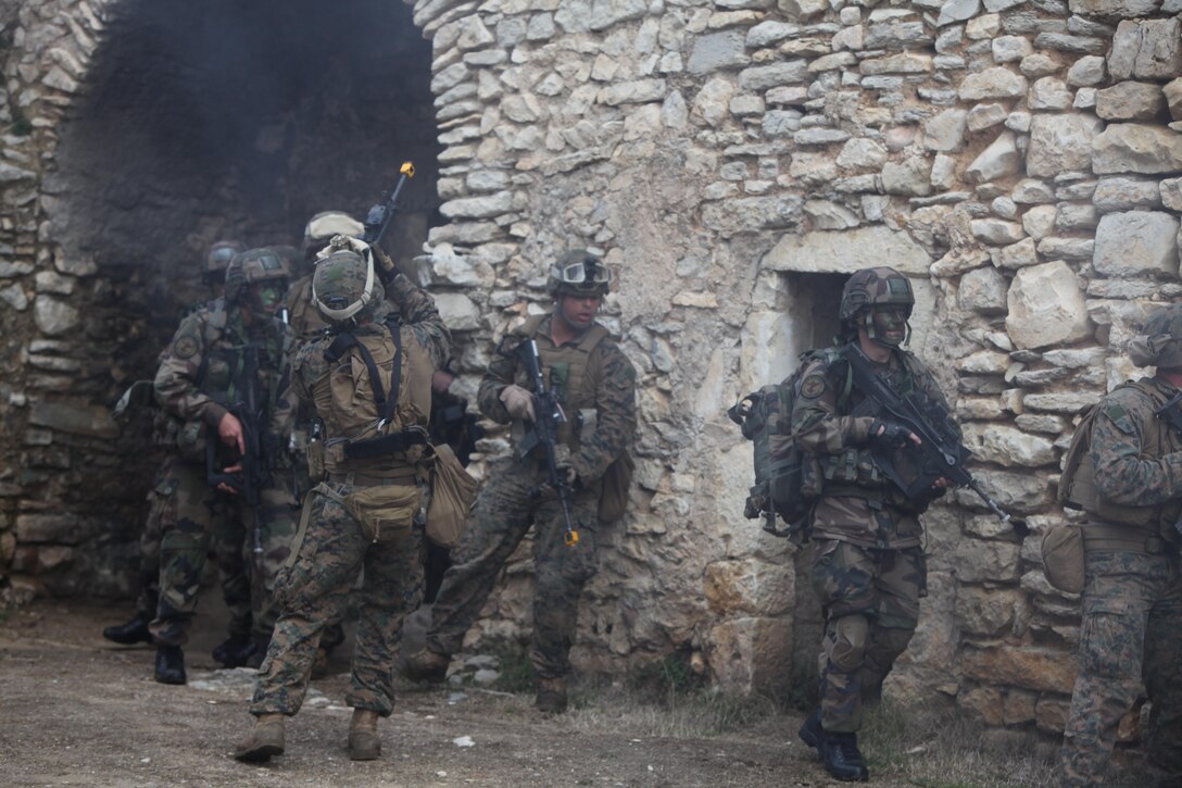 Marines from the United States and France assault an objective during a simulated raid on a suspected enemy compound at Camp de Garrigues, outside of Nîmes, France, Feb. 13, 2014. The purpose of the week-long bilateral training was to enhance interoperability between the two allied militaries.