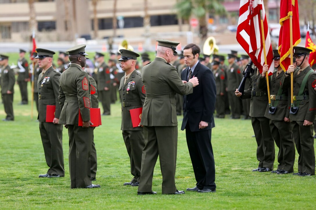 Nicholas Brandau, former squad leader, 1st Battalion, 7th Marine Regiment, receives the Silver Star Medal, from Lt. Gen. John Toolan, commanding general of I Marine Expeditionary Force, during an award ceremony held at Marine Corps Air Ground Combat Center Twentynine Palms, Calif., Feb. 18, 2014. Brandau was recognized for his heroic actions in Afghanistan when he maintained a tactical advantage while being ambushed by a larger enemy force. Brandau saved the lives of multiple Marine during the six-day operation. (U.S. Marine Corps Photo by Lance Cpl. Christopher J. Moore/released)