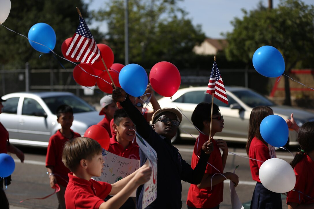 Mira Mesa Christian School students, ranging from 3rd to 6th grade, carry flags, signs and balloons to support American service members by the north gate of Marine Corps Air Station Miramar, Calif., Feb. 20. The children would shout chants such as “honk for America” for cars entering and leaving the installation. 