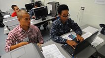 U.S. Air Force Senior Airman Edward Lim, 324th Intelligence Squadron linguist, assists U.S. Navy Petty Officer 3rd Class Mary Chamber, Navy Information Operations Center, as she files her 2013 income taxes at the tax center on Joint Base Pearl Harbor-Hickam, Feb. 19, 2014. Last year the JBPHH tax center processed over 670 federal returns.    (U.S. Air Force photo/Master Sgt. Jerome S. Tayborn) 
