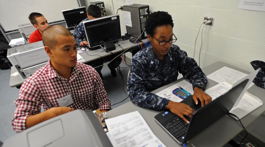 U.S. Air Force Senior Airman Edward Lim, 324th Intelligence Squadron linguist, assists U.S. Navy Petty Officer 3rd Class Mary Chamber, Navy Information Operations Center, as she files her 2013 income taxes at the tax center on Joint Base Pearl Harbor-Hickam, Feb. 19, 2014. Last year the JBPHH tax center processed over 670 federal returns.    (U.S. Air Force photo/Master Sgt. Jerome S. Tayborn) 