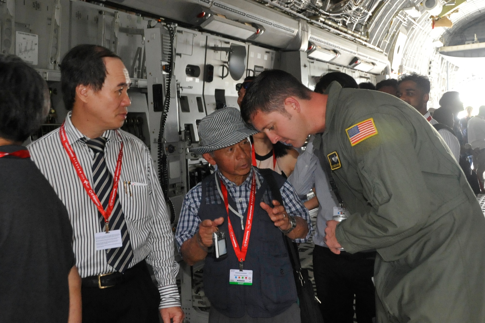 Tech. Sgt. Jesse Richardson, C-17 Globemaster III demonstration team member from the 535th Airlift Squadron at Joint Base Pearl Harbor-Hickam, Hawaii, answers questions for people attending the 2014 Singapore International Airshow, Feb. 11, 2014. The C-17 performed aerial demonstrations showcasing its capabilities to more than 100,000 spectators at the airshow. (U.S. Air Force photo/Capt. Tamara Fischer-Carter)
 
