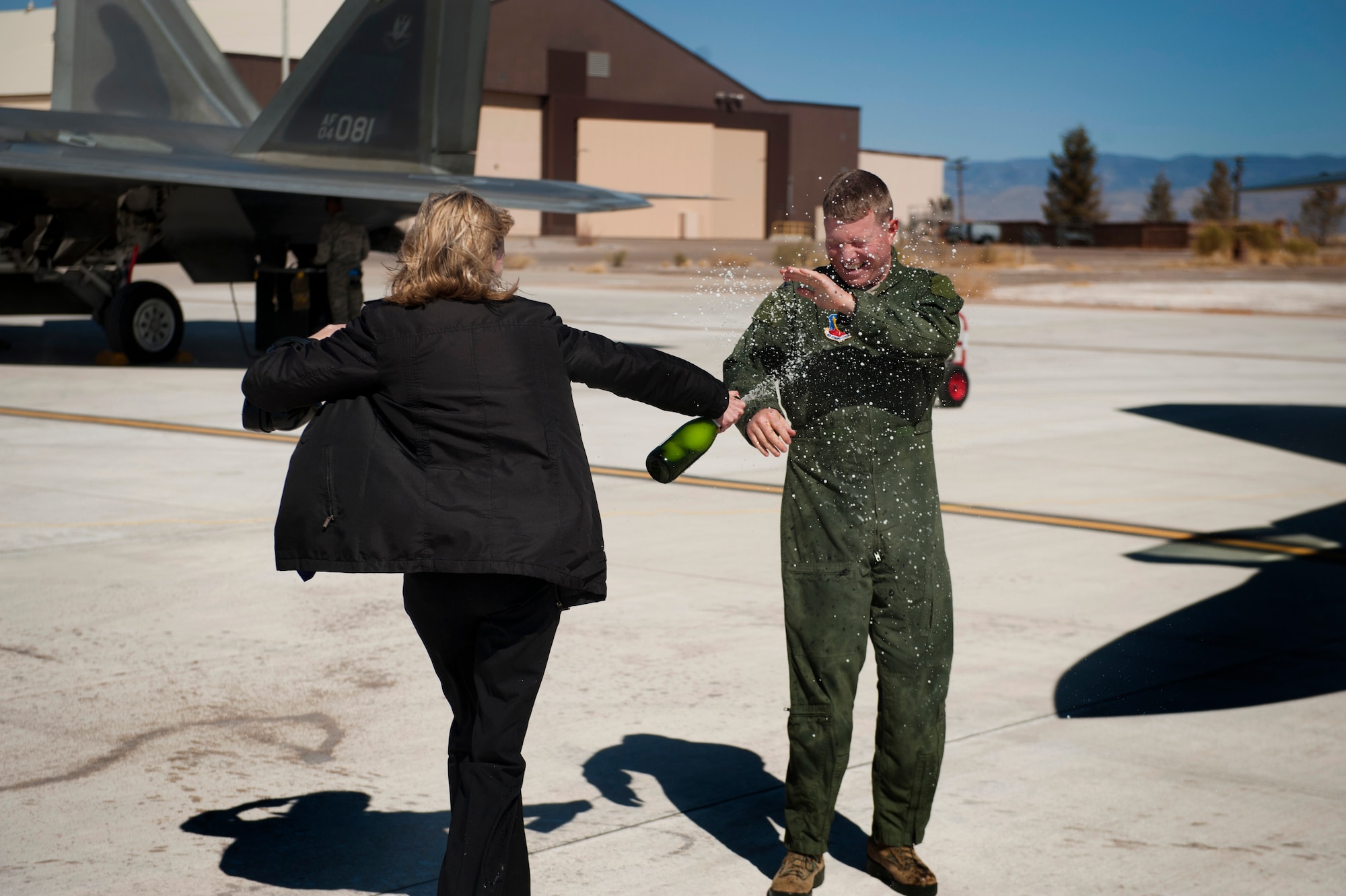 Vicki Croft sprays champagne on Col. Andrew Croft, 49th Wing commander, after his final flight in the F-22 Raptor at Holloman Air Force Base, N.M., Feb. 20. The 7th Fighter Squadron and members of the Holloman community celebrated this sortie before the F-22s depart for Tyndall Air Force Base, Fla., in early April. (U.S. Air Force photo by Airman 1st Class Aaron Montoya / Released)