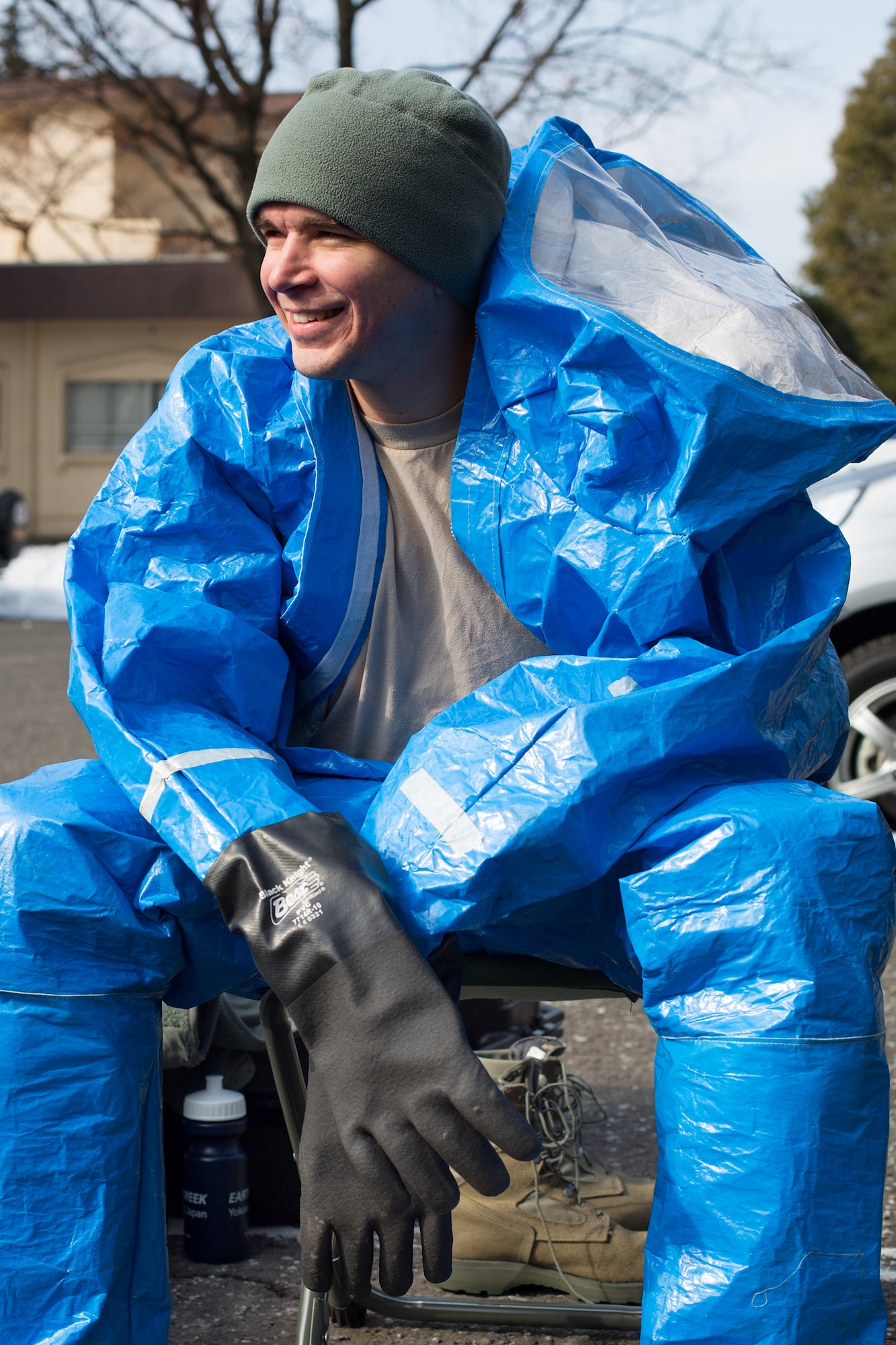 Senior Airman Luke Luallin, 374th Civil Engineer Squadron emergency management technician, rests prior to a hazardous material training exercise at Yokota Air Base, Japan, Feb. 20, 2014. The primary purpose of the exercise was joint crime scene preservation training among emergency management, bioenvironmental engineers, fire department, security forces, medical technicians, and Air Force Office of Special Investigations to ensure minimal scene disturbance while completing presumptive identification, sampling and evidence collection. (U.S. Air Force photo by Osakabe Yasuo/Released)