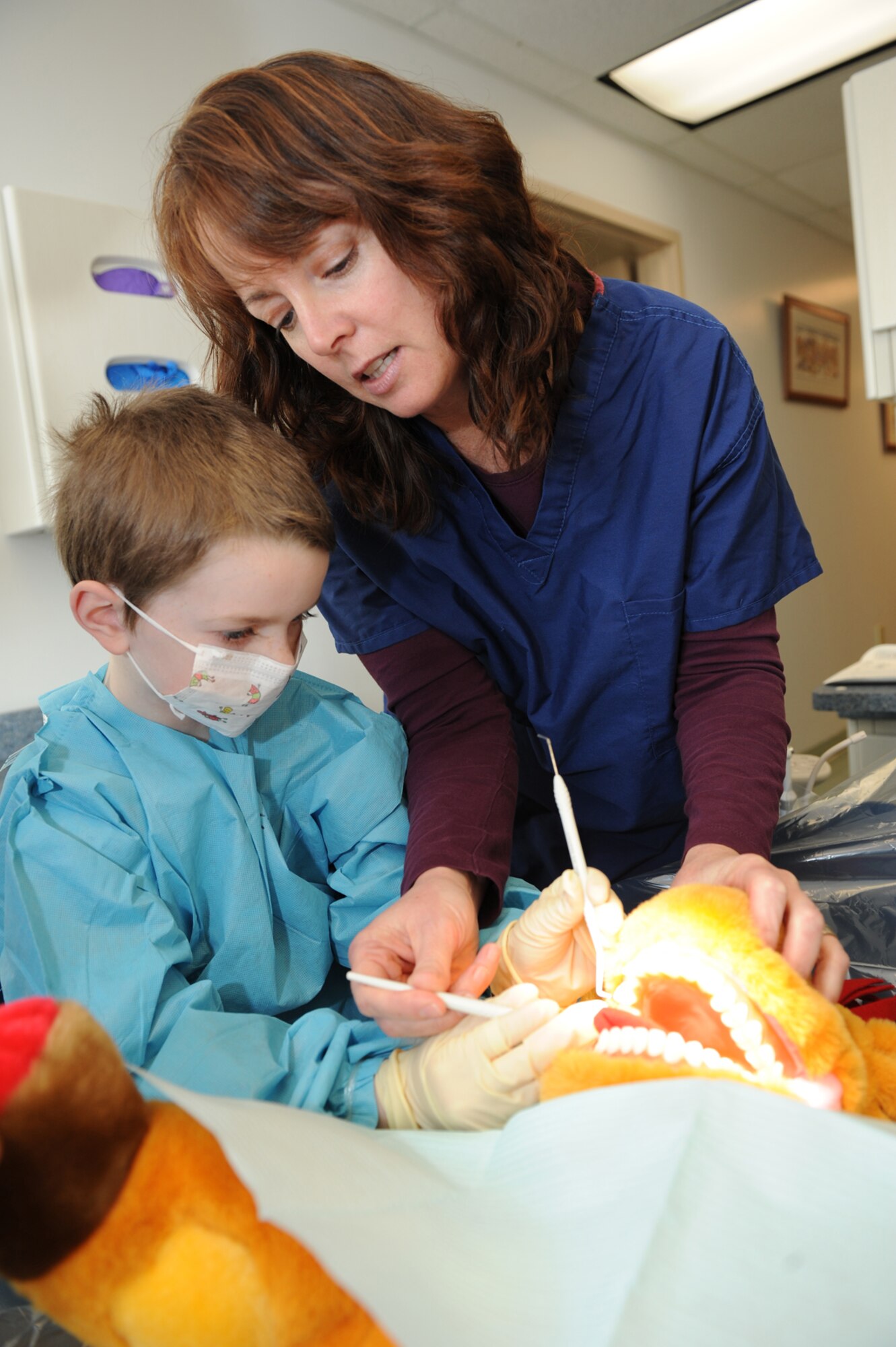 Regan Moir, a dental hygienist with the Rockmore King Clinic at Coast Guard base Kodiak, helps a Chiniak Elementary student clean a stuffed animal’s teeth Feb. 28, 2011, at the base clinic during a visit from Chiniak students for Children’s Dental Health Month. (U.S. Coast Guard photo/Petty Officer 3rd Class Charly Hengen)
