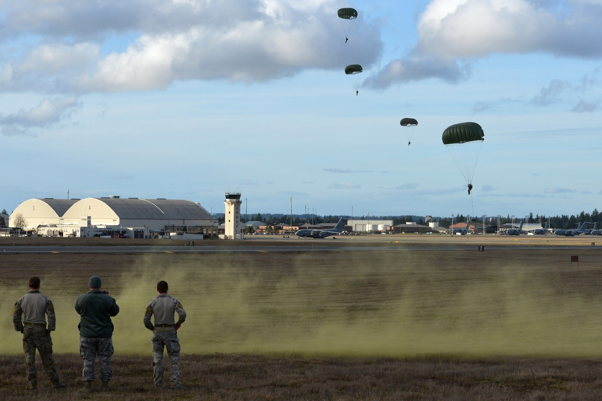 Combat controllers from the 22nd Special Tactics Squadron perform a static line jump while spotters on the ground look on, Feb. 12, 2014, at Joint Base Lewis-McChord, Wash. The airmen try to land as close to the landing zone as they can in high winds. (U.S. Air Force photo/Staff Sgt. Russ Jackson)
