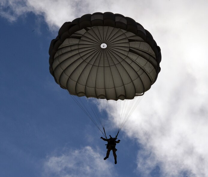 Senior Airman Christopher Beitia, 22nd Special Tactics Squadron combat controller spots his landing after his static line jump from a C-17 Globemaster III above McChord Field, Feb. 12, 2014 at Joint Base Lewis-McChord, Wash. Static line jumpers have limited maneuverability during their drop, so they must rely on the aircraft to drop them as close as possible to the landing zone. (U.S. Air Force photo/Staff Sgt. Russ Jackson)