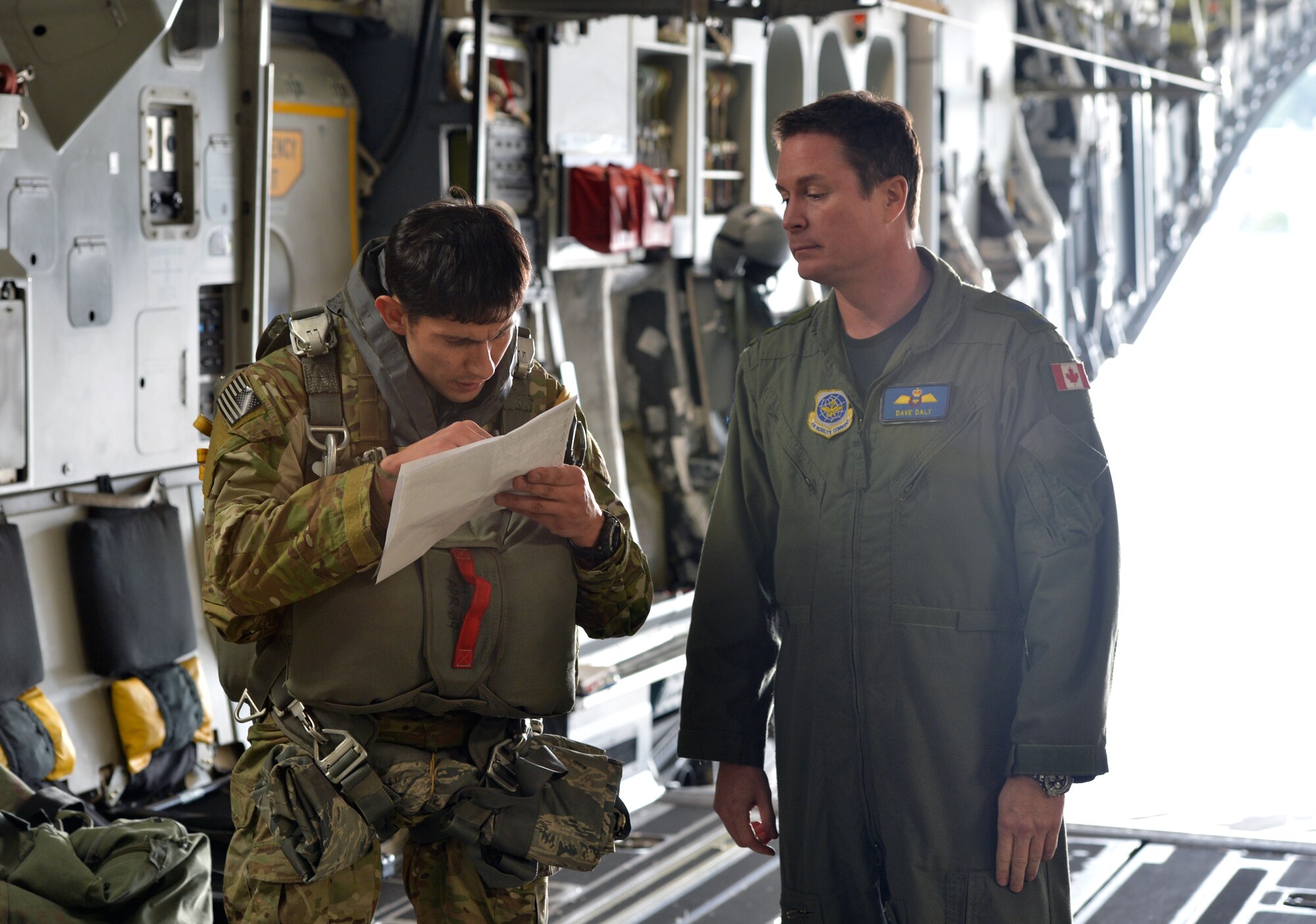 Left, Master Sgt. Juan Moran, 22nd Special Tactics Squadron jumpmaster checks the jump manifest with Warrant Officer Dave Daly, 7th Airlift Squadron loadmaster, Feb. 12, 2014 at Joint Base Lewis-McChord, Wash. The members also calculate wind speed and the jumping point based on landmarks before arriving at the landing zone. (U.S. Air Force photo/Staff Sgt. Russ Jackson) 