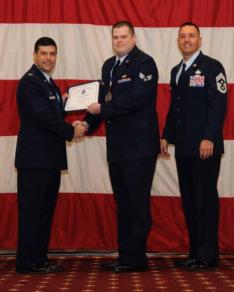 Senior Airman Alan Stratton, 2nd Communications Squadron, receives an Airman Leadership School graduation certificate from Col. Andrew Gebara, 2nd Bomb Wing commander, on Barksdale Air Force Base, La., Feb. 13, 2014. (U.S. Air Force photo/Senior Airman Joseph A. Pagán Jr.)