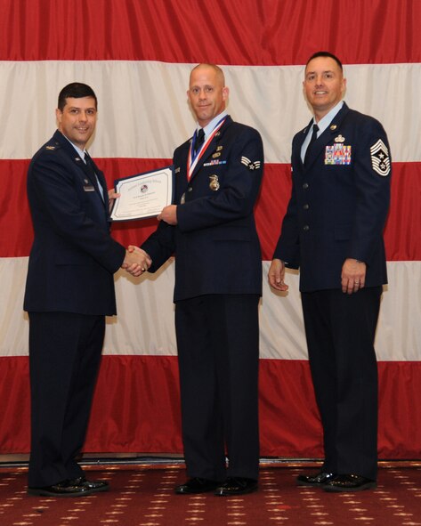 Senior Airman Randy Patrick, 307th Security Forces Squadron, receives an Airman Leadership School graduation certificate from Col. Andrew Gebara, 2nd Bomb Wing commander, on Barksdale Air Force Base, La., Feb. 13, 2014. (U.S. Air Force photo/Senior Airman Joseph A. Pagán Jr.)