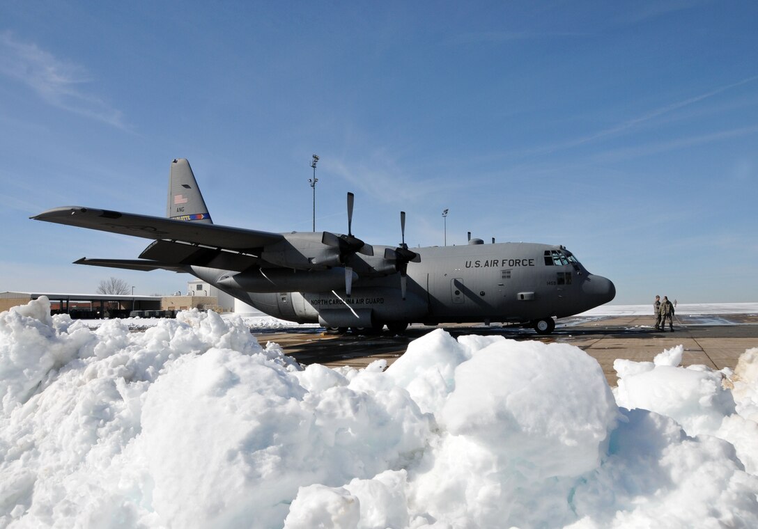 After being pulled out of a maintenance hangar where it was kept secure from the storm and mission ready, a 145th Airlift Wing C-130 Hercules aircraft waits on tarmac at the North Carolina Air National Guard base, Charlotte Douglas Intl. airport, February 14, 2014.  Winter-weary from the second winter storm of the season, the 145th Maintenance and Logistic Readiness Squadrons continued maintaining and moving planes and cargo, diligently staying focused on the mission. (U.S. Air National Guard photo by Master Sgt. Patricia F. Moran, 145th Public Affairs/Released)