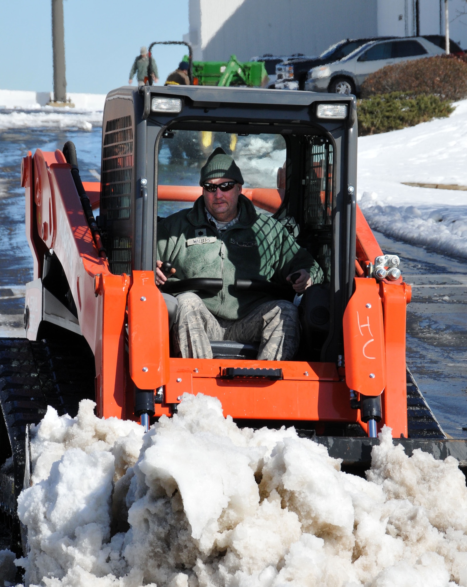U.S. Air Force Lt. Col. Gregory Walters, commander, 145th Civil Engineer Squadron, operates a skid steer loader to remove snow and ice off roads at the North Carolina Air National Guard base, Charlotte Douglas Intl. airport, February 14, 2014.  The winter storm, which brought over six inches of snow and finished with a blanket of ice, made roads dangerous throughout the entire state and left many households and businesses without power. (U.S. Air National Guard photo by Master Sgt. Patricia F. Moran, 145th Public Affairs/Released)