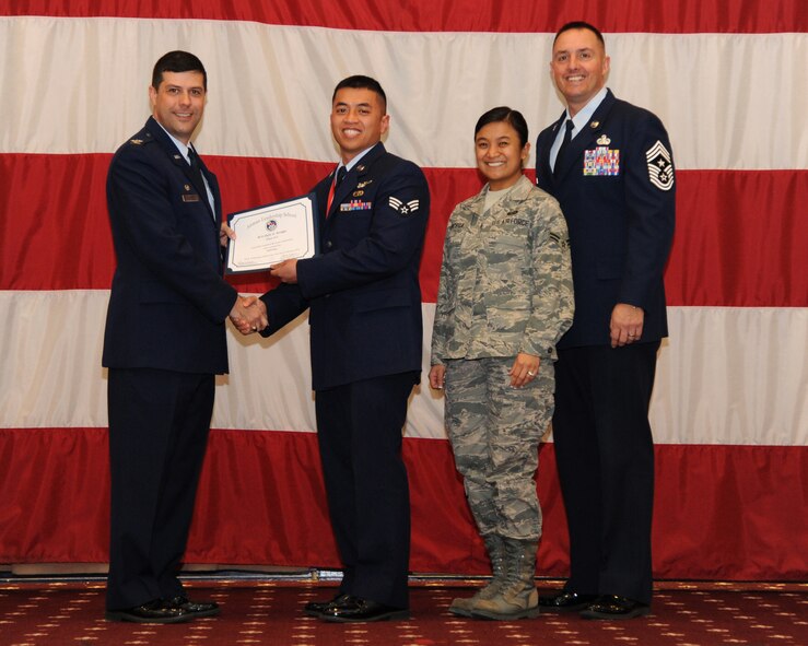 Senior Airman Jojie Arcega, 2nd Maintenance Squadron, receives an Airman Leadership School graduation certificate from Col. Andrew Gebara, 2nd Bomb Wing commander, on Barksdale Air Force Base, La., Feb. 13, 2014. (U.S. Air Force photo/Senior Airman Joseph A. Pagán Jr.)
