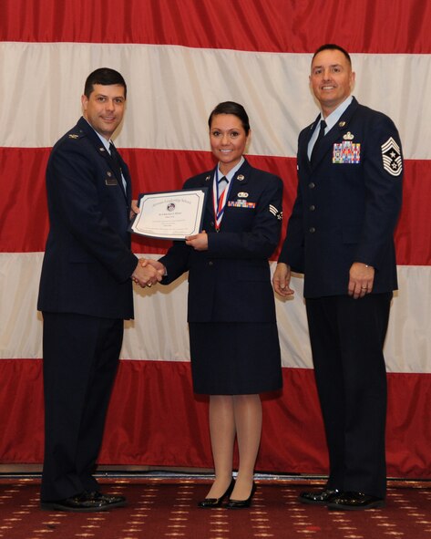 Senior Airman Karina Reyes, 2nd Contracting Squadron, receives an Airman Leadership School graduation certificate from Col. Andrew Gebara, 2nd Bomb Wing commander, on Barksdale Air Force Base, La., Feb. 13, 2014. (U.S. Air Force photo/Senior Airman Joseph A. Pagán Jr.)