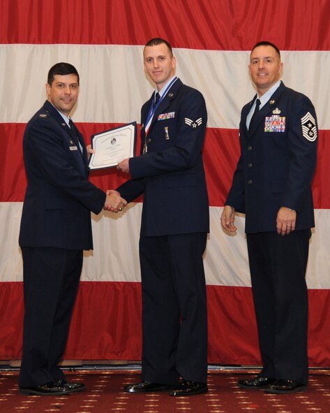 Senior Airman Ryan Walker, 2nd Munitions Squadron, receives an Airman Leadership School graduation certificate from Col. Andrew Gebara, 2nd Bomb Wing commander, on Barksdale Air Force Base, La., Feb. 13, 2014. (U.S. Air Force photo/Senior Airman Joseph A. Pagán Jr.)
