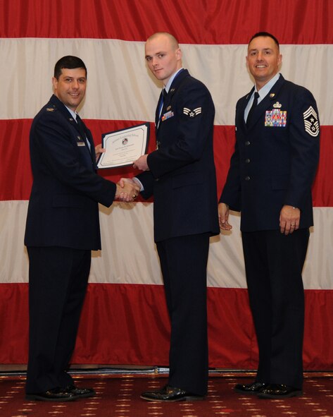 Senior Airman Trevor Szewczak, 608th Air and Space Operations Center, receives an Airman Leadership School graduation certificate from Col. Andrew Gebara, 2nd Bomb Wing commander, on Barksdale Air Force Base, La., Feb. 13, 2014. (U.S. Air Force photo/Senior Airman Joseph A. Pagán Jr.)