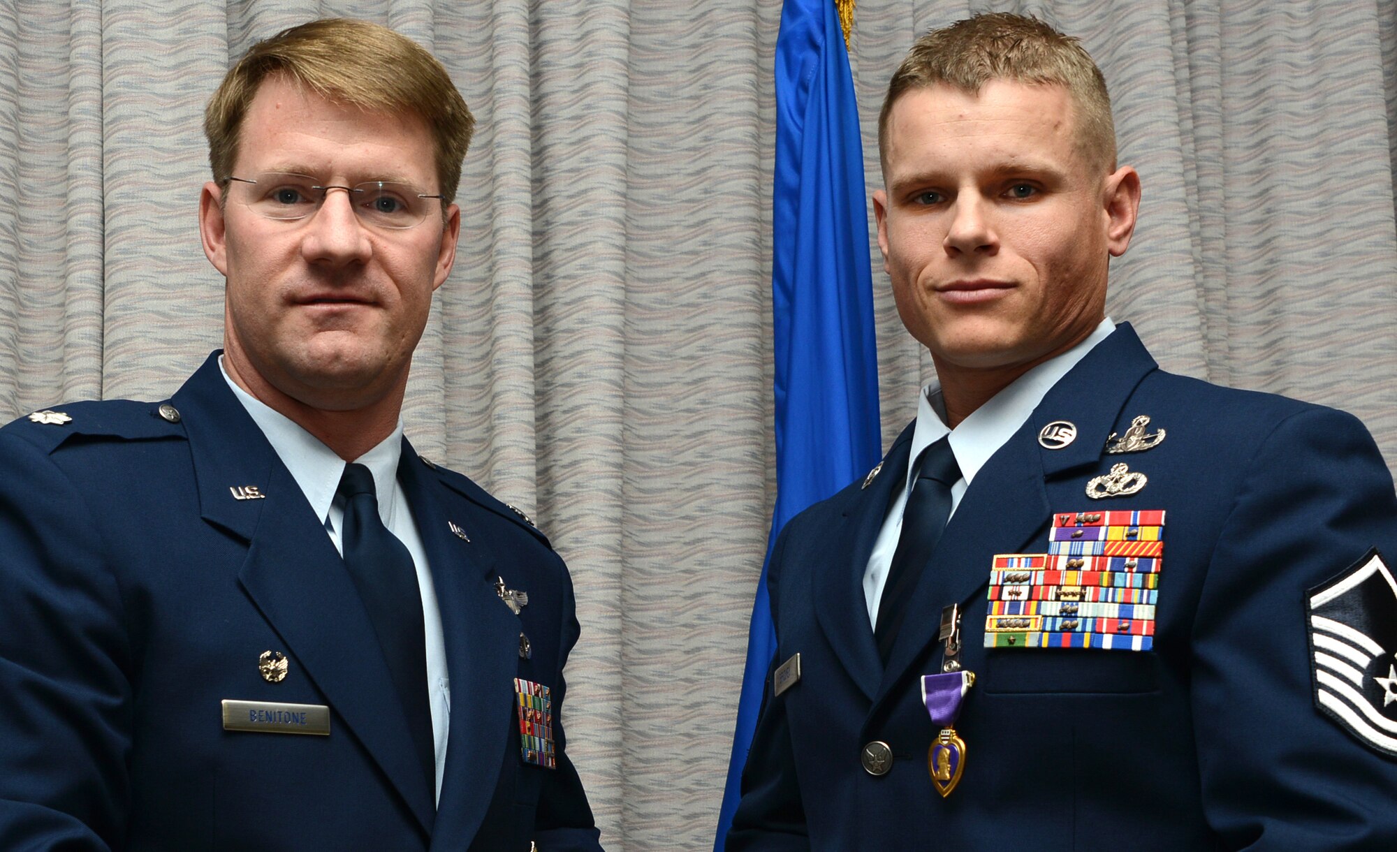 Lt. Col. Trevor Benitone, United States Air Force Special Operations School commandant, poses for a photo with Master Sgt. Ronnie Brickey, USAFSOS Force Protection Branch NCO in charge, after presenting him with the Purple Heart Feb. 20, 2014, at Hurlburt Field, Fla. This is the second Purple Heart Brickey has received during his Air Force career in Explosive Ordnance Disposal. (U.S. Air Force photo by Master Sgt. Steven Pearsall)