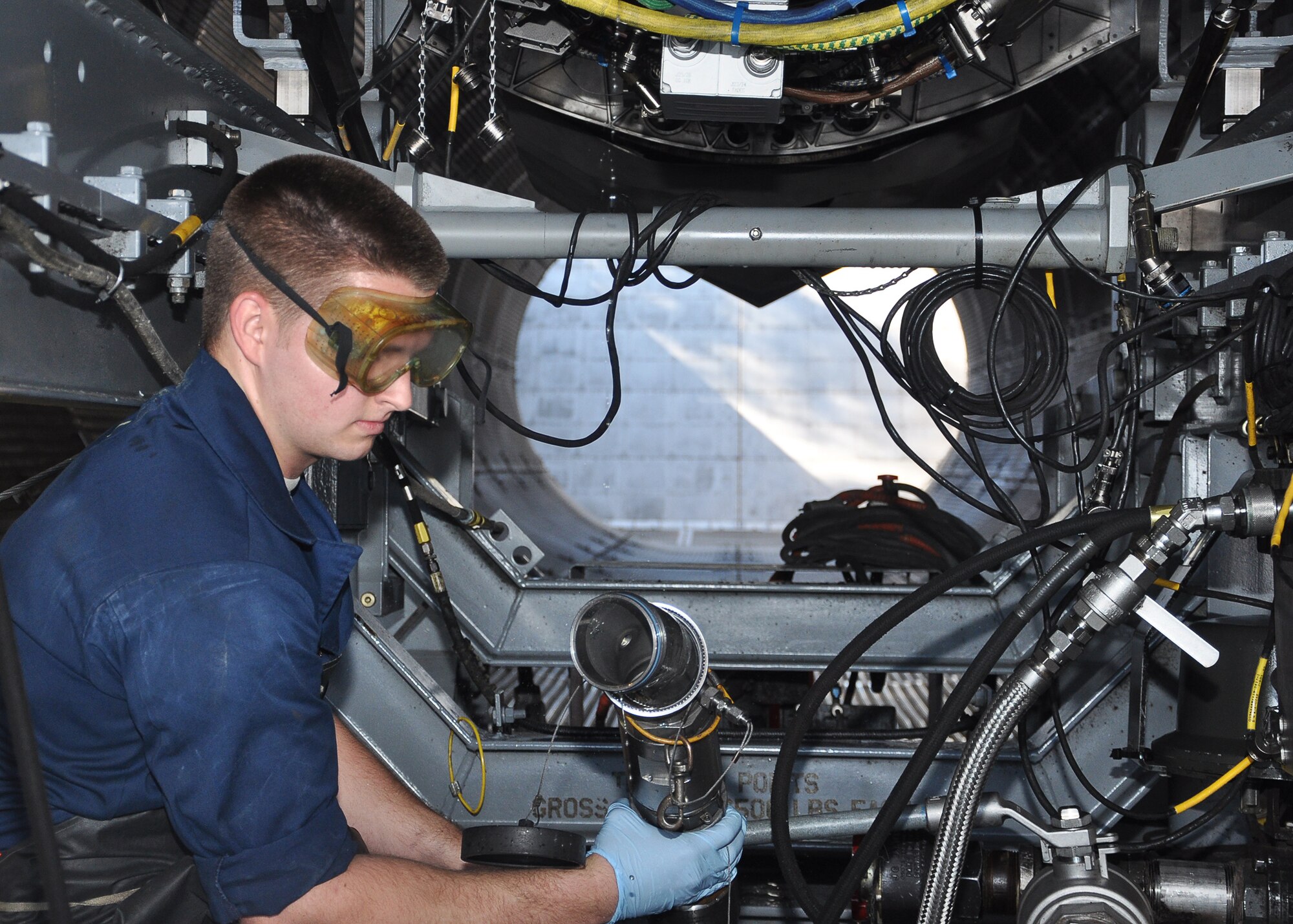 Airman 1st Class Dwayne Traynor, 325th Maintenance Squadron aerospace propulsion technician, readies a hose for the F-119 F-22 Raptor engine Feb. 20 at the Test Cell. This is a step in an indoor test of an engine. (U.S. Air Force photo by Airman 1st Class Solomon Cook)